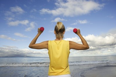 Jupiterimages/Comstock/Getty Images Dumbbell exercises can help build strength and tone muscles needed for swimming.