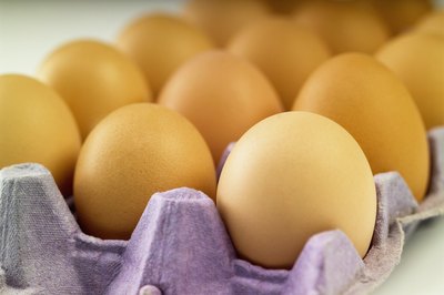 Medioimages/Photodisc/Photodisc/Getty Images Store raw eggs in the refrigerator to reduce the risk of food poisoning.