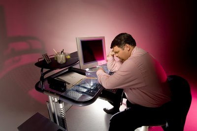 Creatas Images/Creatas/Getty Images Slouching at your desk can cause back and neck pain.