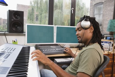 Jupiterimages/Creatas/Getty Images A career path toward becoming a music producer includes jobs in the technical, business and creative fields.