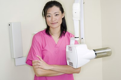 Creatas Images/Creatas/Getty Images A dental hygienist assists a dentist by cleaning a patient's teeth and providing advice on oral health.