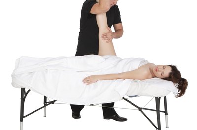 PhotoObjects.net/PhotoObjects.net/Getty Images Assisted stretching can improve hamstring and leg flexibility.
