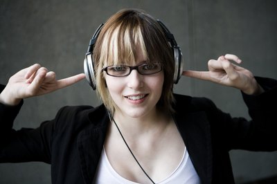 Jupiterimages/Photos.com/Getty Images Listening to tunes on headphones can drown out the noise.