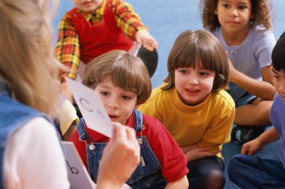 Stockbyte/Stockbyte/Getty Images Literacy specialists improve a child's ability to read, write, speak and listen.