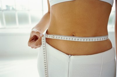 George Doyle/Stockbyte/Getty Images Eating the right foods and doing the proper exercises can earn you a trim belly.