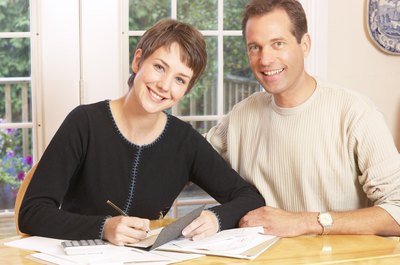 Hemera Technologies/AbleStock.com/Getty Images Create a budget together so both of you understand the household finances.