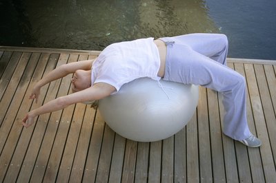 Goodshoot/Goodshoot/Getty Images Use your ball to loosen up tight, stiff back muscles.