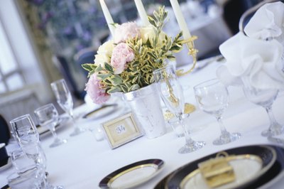 Buccina Studios/Photodisc/Getty Images Table settings for your wedding can be rented, purchased or borrowed.