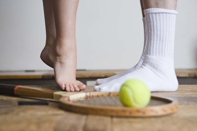 Jupiterimages/BananaStock/Getty Images Standing on your tip toes repeatedly is another way to strengthen your arches.