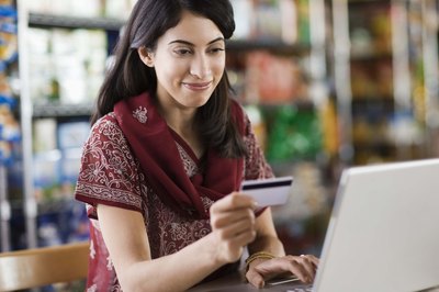 Jupiterimages/Brand X Pictures/Getty Images Use credit cards wisely and pay off balances each month to help increase your credit score.