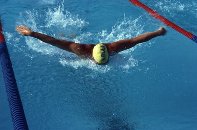 Jupiterimages/Photos.com/Getty Images Strong arms are required to propel your body forward in the butterfly stroke.