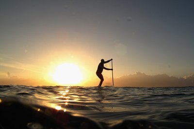 Cameron Spencer/Getty Images Sport/Getty Images The paddling motion of SUP works your abs.