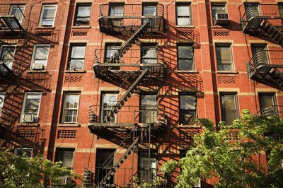 Medioimages/Photodisc/Photodisc/Getty Images An apartment building can bring in steady rental income.