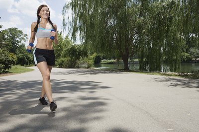 Jupiterimages/Brand X Pictures/Getty Images Carrying light weights adds resistance to your jogging routine.