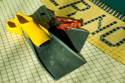 Jupiterimages/Photos.com/Getty Images Swim fins can help improve proper kicking technique.