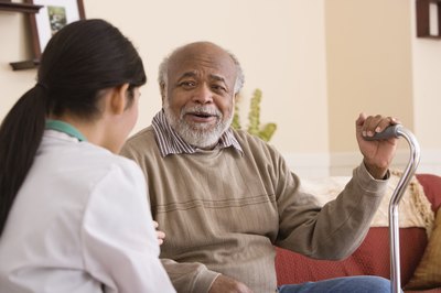 Jupiterimages/Comstock/Getty Images A nurse's aide often work with elderly or disabled patients.