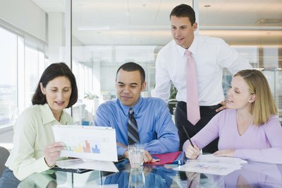 Jupiterimages/Creatas/Getty Images Business analysts meet with customers to review documents.