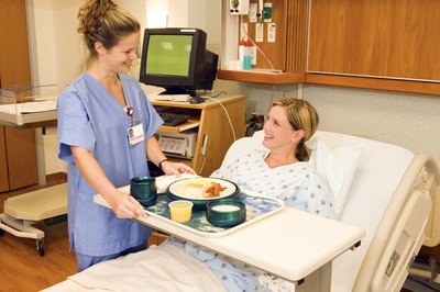 Jupiterimages/Comstock/Getty Images Dietary aides deliver nourishment to the sick and injured in hospitals.