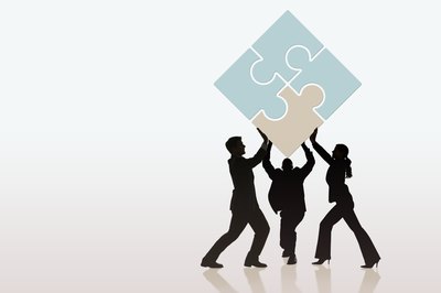 Jupiterimages/Comstock/Getty Images Collaborating at work can ease your workload.
