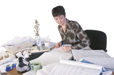 Hemera Technologies/PhotoObjects.net/Getty Images Cost accountants prepare budgets and evaluate company performance and expenditures.