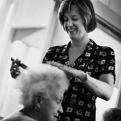Keith Brofsky/Photodisc/Getty Images Nursing aides help with meals, grooming and other day-to-day needs.