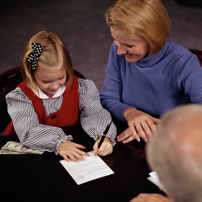 Keith Brofsky/Photodisc/Getty Images A parent is often a cosigner for a child's account.