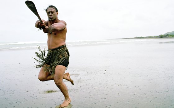 An indigenousness Maori dances on a beach.