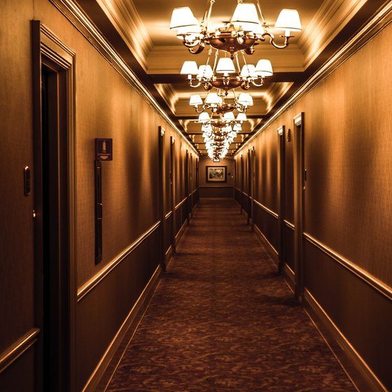 A hotel hallway with chandeliers and carpet.