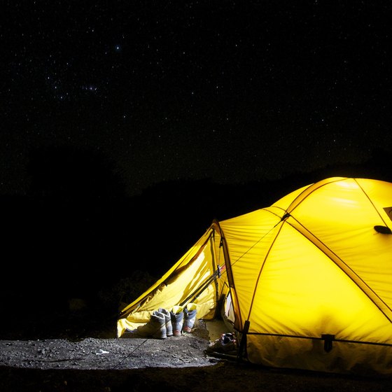 A yellow tent camping in the pitch dark night.