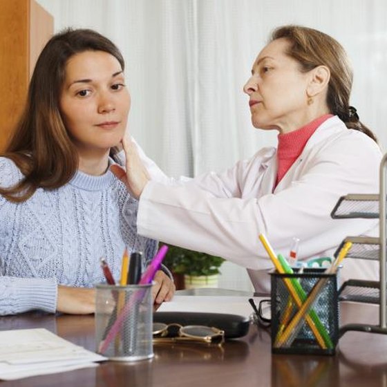 A woman having her ear exam end by a doctor.