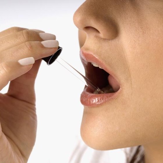 Woman with medicine dropper in her mouth