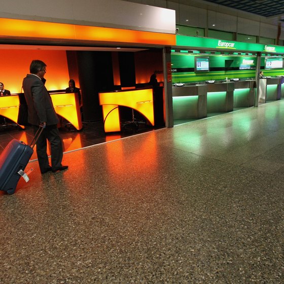 Traveler walks near car rental counters inside airport