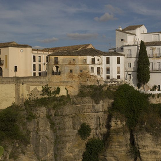 The white-washed houses in Ronda cling to its craggy limestone cliff face.