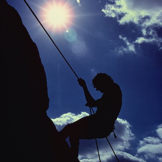 A climber rappels down a cliff face.