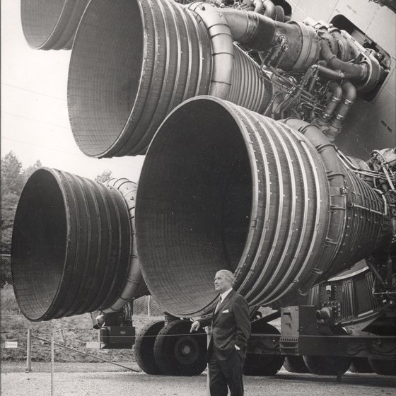 This archival shot shows rocket scientist Werner von Braun in Huntsville, standing next to his masterpiece, the Saturn V.