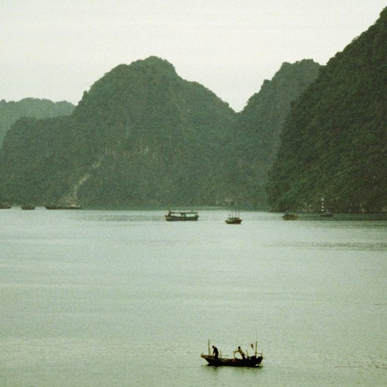 Vessels dock close to the cliffs along the waters of Halong Bay.