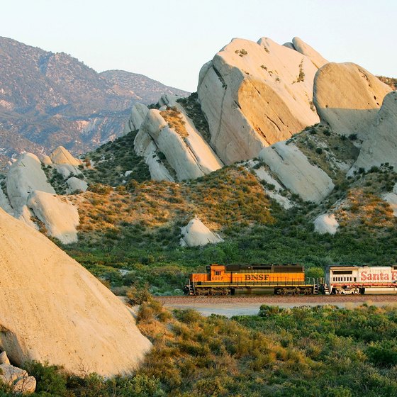 A freight train moves through Cajon Pass and past the distinctive Mormon Rocks in California's San Bernardino National Forest.