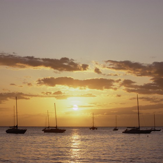 Sailboats perch off Maui's calm coastal waters at dusk.