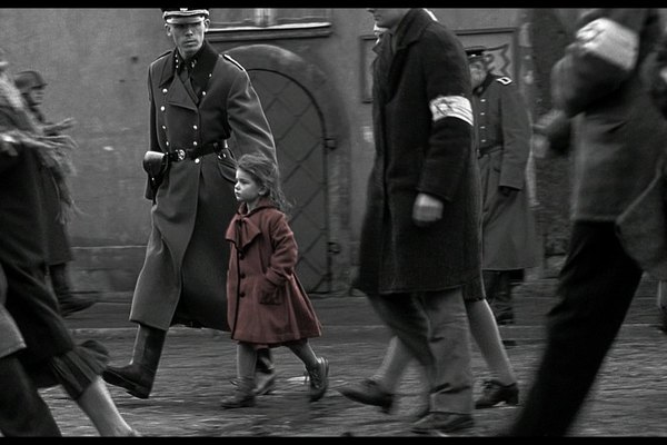 La pequeña con el tapado rojo es escoltada por un soldado de las SS