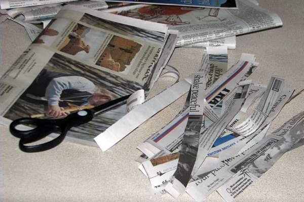 Corta el periódico con tijeras para hacer tiras.