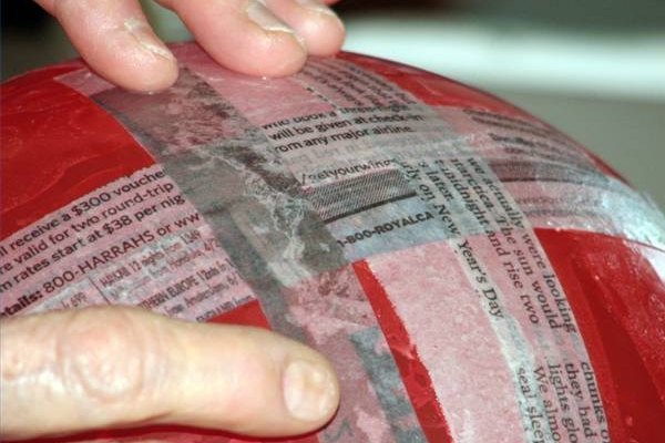 Añade las tiras al periódico con engrudo.