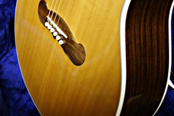 El puente de una guitarra acústica tiene clavijas que sostienen las cuerdas en su lugar.