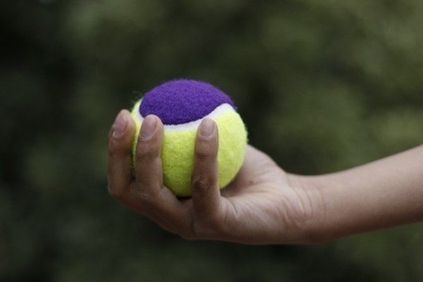 Apretar una pelota de tenis es un ejemplo de un ejercicio para reforzar las manos de los niños.