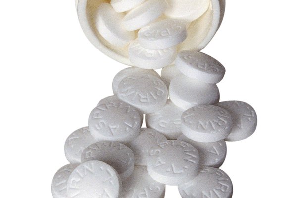 Bottle of aspirin lying on its side, tablets spilling out