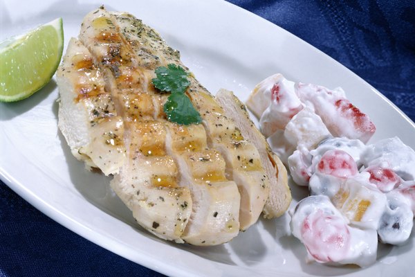 A close-up of a boneless chicken breast and fruit salad