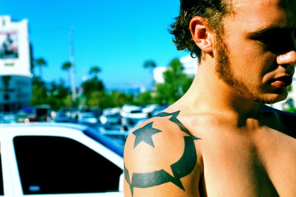 Hombre con tatuaje de estrella en el hombro.