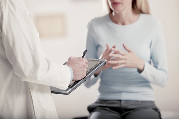 Doctor holding tablet PC talking to patient