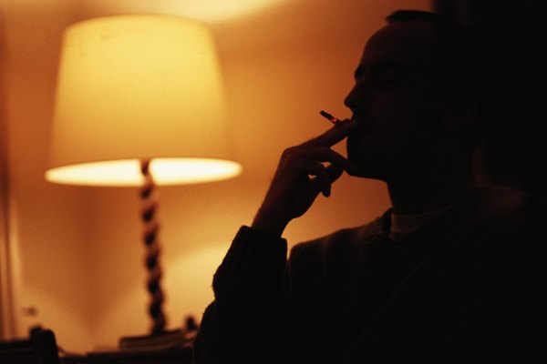 Man smoking by electric lamp, silhouette