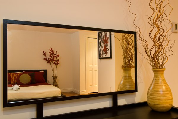 Los espejos planos que se cuelgan en la pared pueden ser adornados agregándoles un borde o marco de madera.