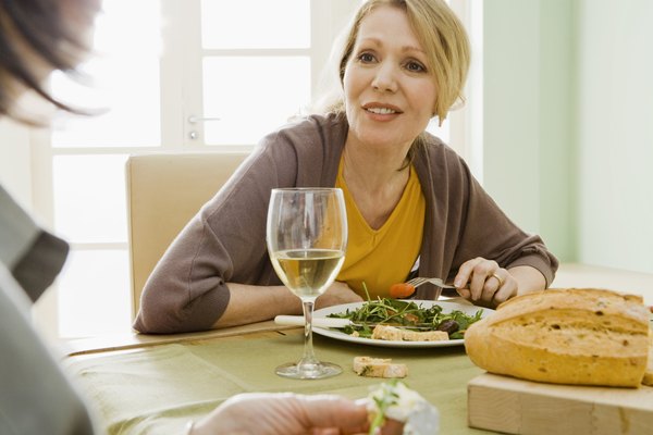 Women eating meal with wine
